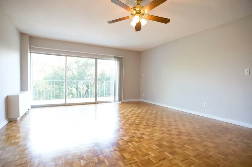 Central Gardens Master Bedroom Before: Blank drywall, brass ceiling fan, and bare parquet floor