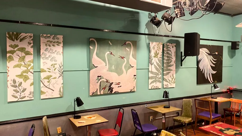 Large-scale custom fabric wall art print with hand-painted details hanging in a local Memphis coffee shop.