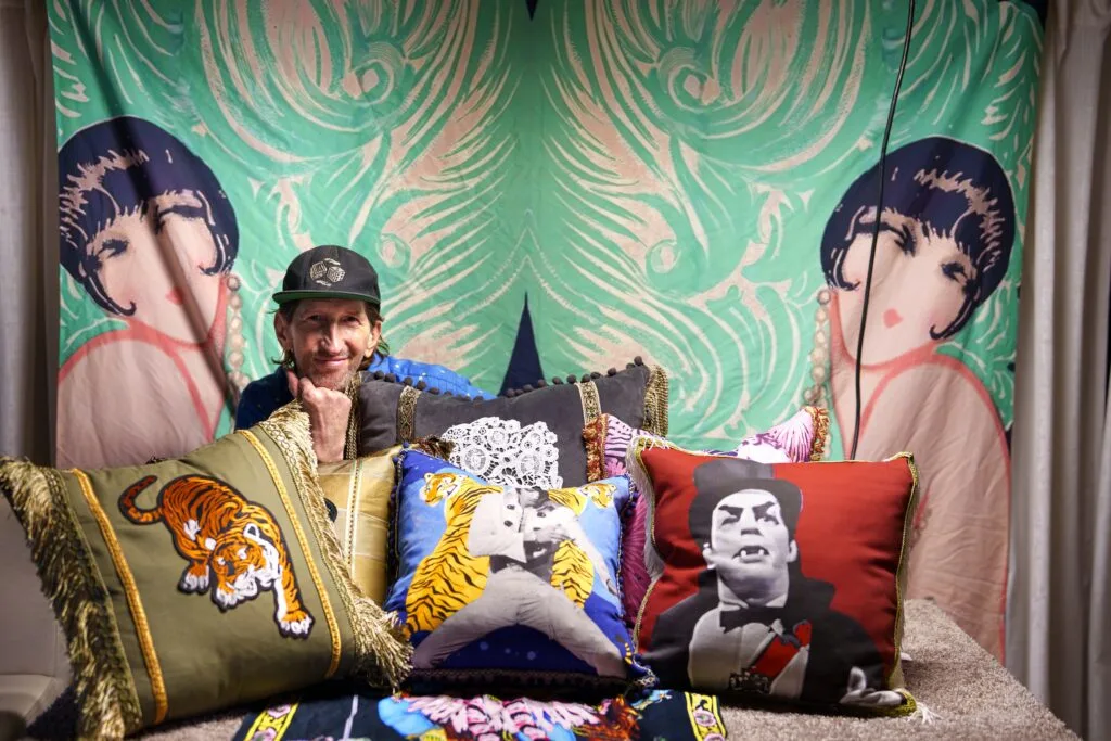 Designer Stevan Collins Lazich showcasing a curated collection of custom throw pillows Memphis style.