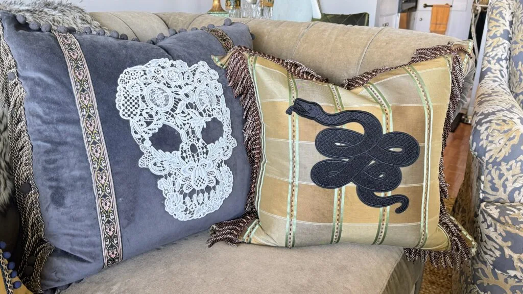 Tattoo-inspired luxury throw pillow with detailed skull, lace embroidery, and snake motif.